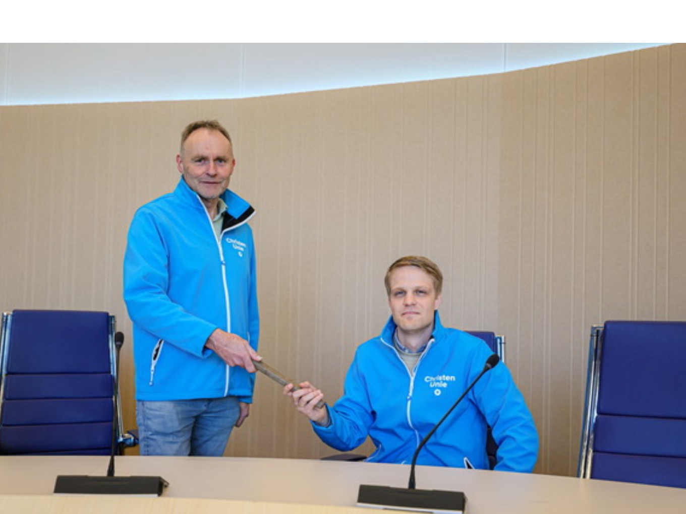 Dick van Gelder (staand) draagt het stokje over aan Thomas Hoekstra. Foto: Marcel van Saltbommel.