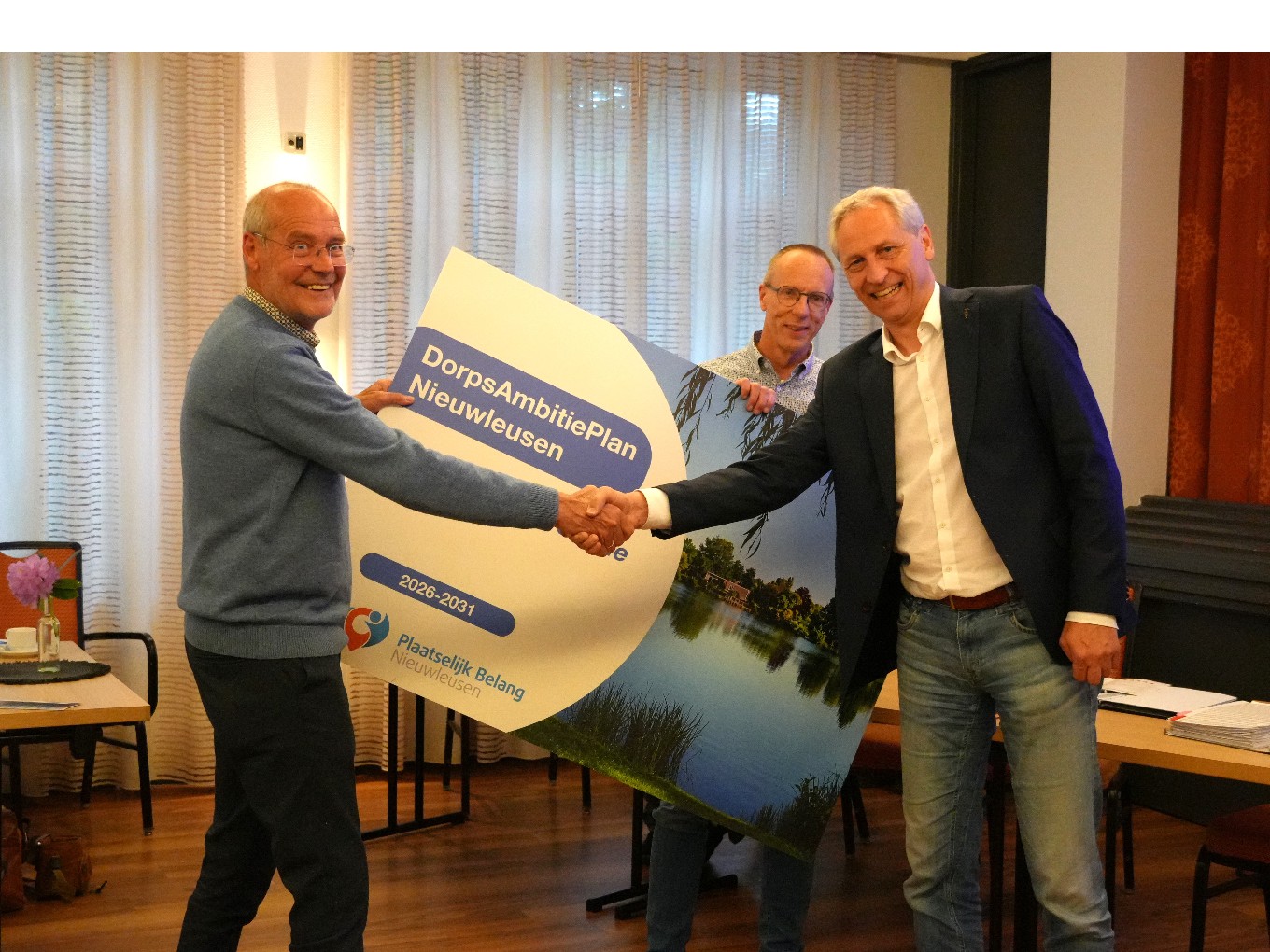het DorpsAmbitiePlan wordt symbolisch aangeboden.