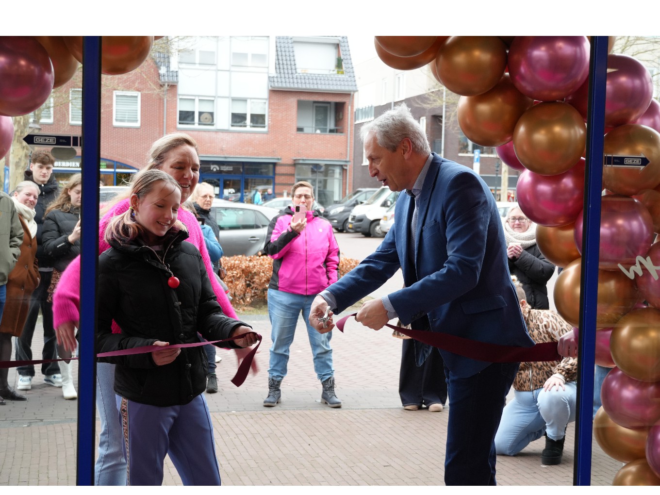 wethouder Jan Uitslag knipt het lint door bij de opening van Het Bakhok in Nieuwleusen.