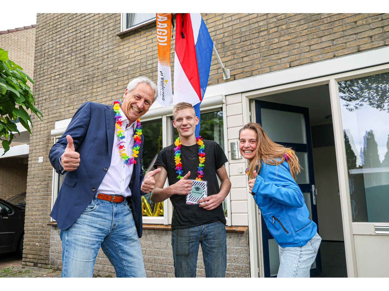 wethouder Jan Uitslag, geslaagde Thijmen Kuiper en Laura Brinkman van Saam.