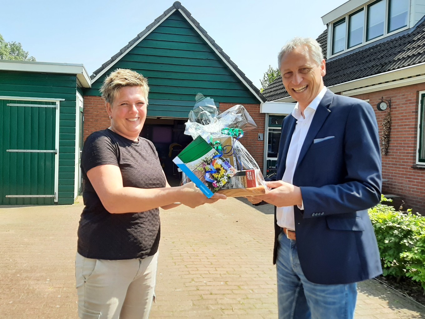 Wethouder Jan Uitslag feliciteert Henriet Broer uit Nieuwleusen. Foto Gemeente Dalfsen.