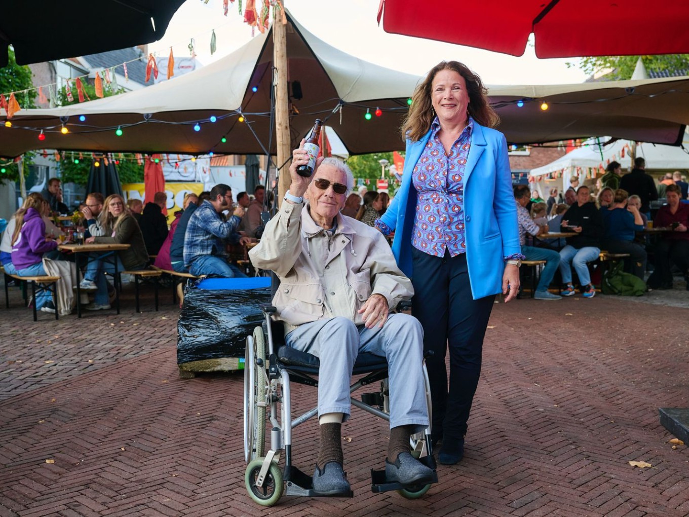 Bestuurder Margot Seip overhandigde het eerste flesje Oonze tuune aan de 92-jarige Piet Snijder, bewoner van het verpleeghuis van Rosengaerde. Foto Robert Westera.